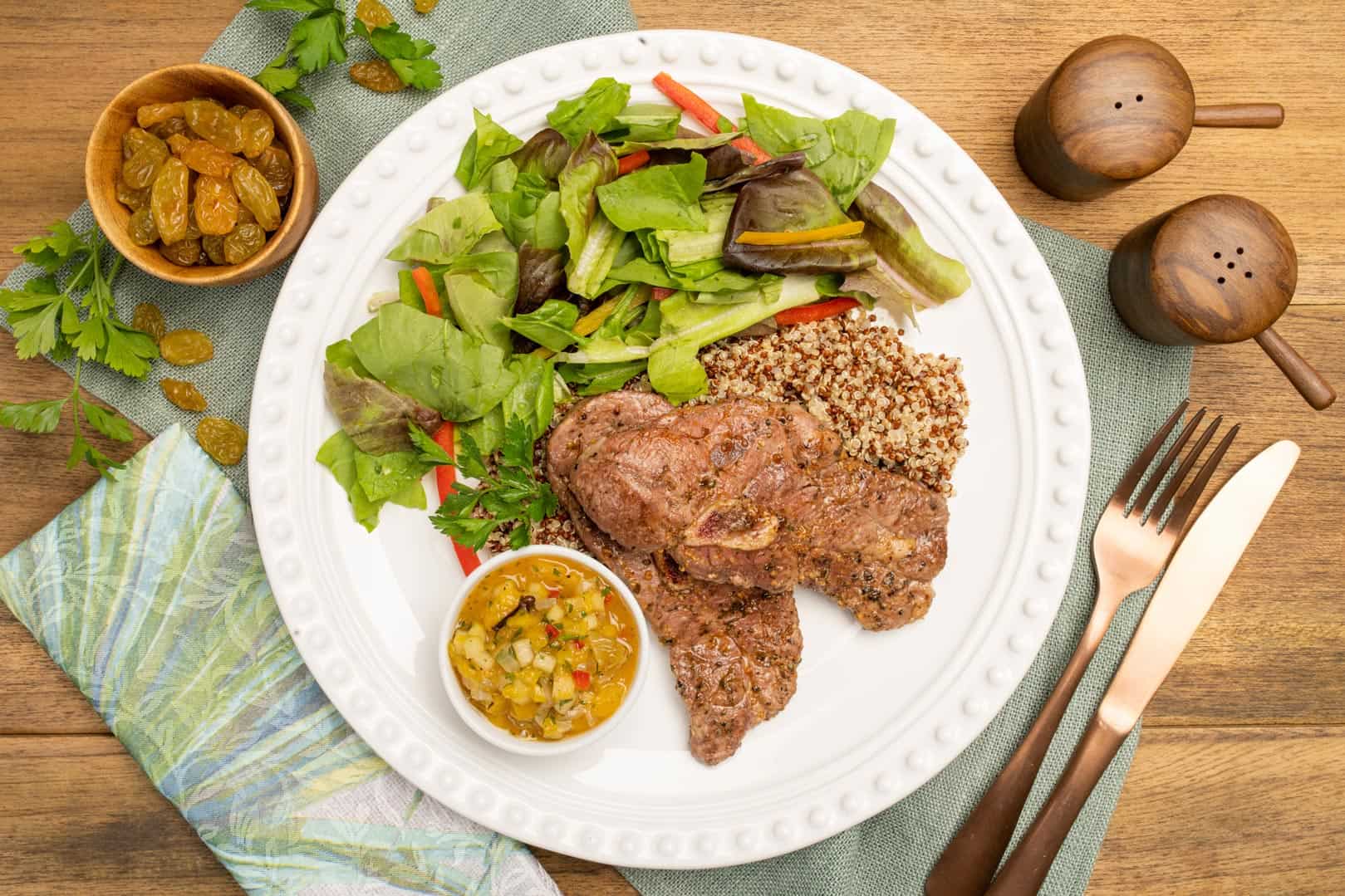 plato de chuletas de cordero con chutney de durazno y quinoa